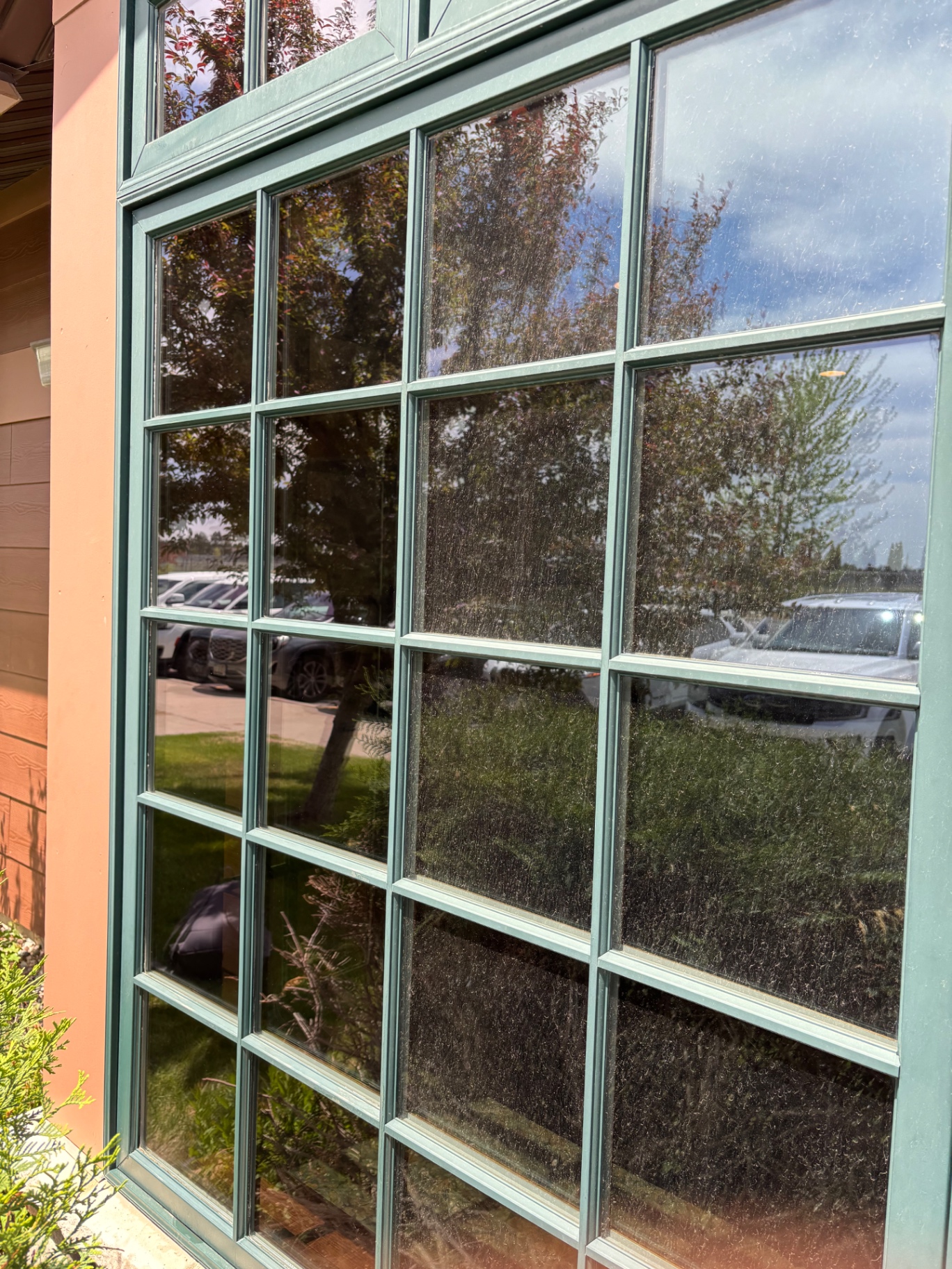 Before photo of dusty multi-pane exterior windows before cleaning