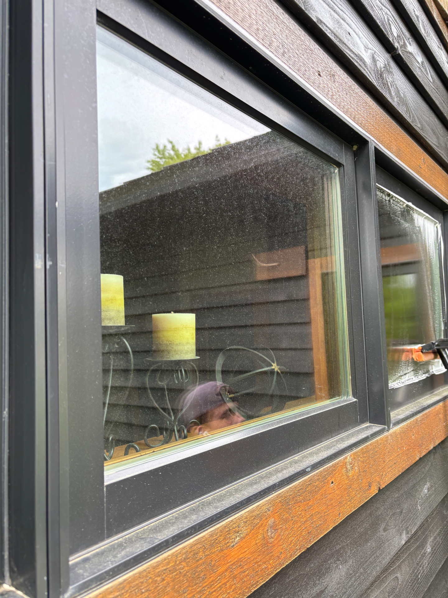 Before photo of a dark framed modern window with dust and buildup on the glass